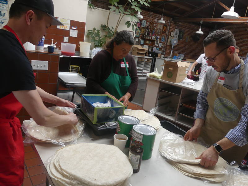 As part of the prep, Wayne Cheung (left), Wendy Dwyer and Michael Kyle separate tortillas. "I find it very gratifying," says Cheung, who started volunteering in February. "I might do this as long as the project lasts."
