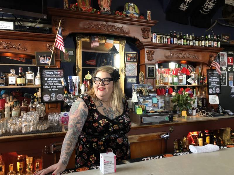 Amy Rothbauer, a bartender at St. Mary's Pub, poses with the box of Narcan that she keeps behind the bar, next to the first aid kit. 