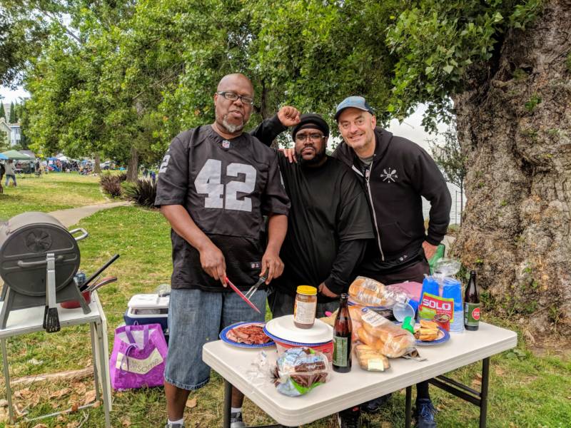 (L-R) Terrance Smith, Brandon Dawkins and Will Morrison grill some burgers at Lake Merritt on Sunday. Smith moved here from Louisiana 20 years ago. 'No matter where we’re from, we are all Oakland, and we’re not going anywhere, and there’s nothing they can do to change that.'