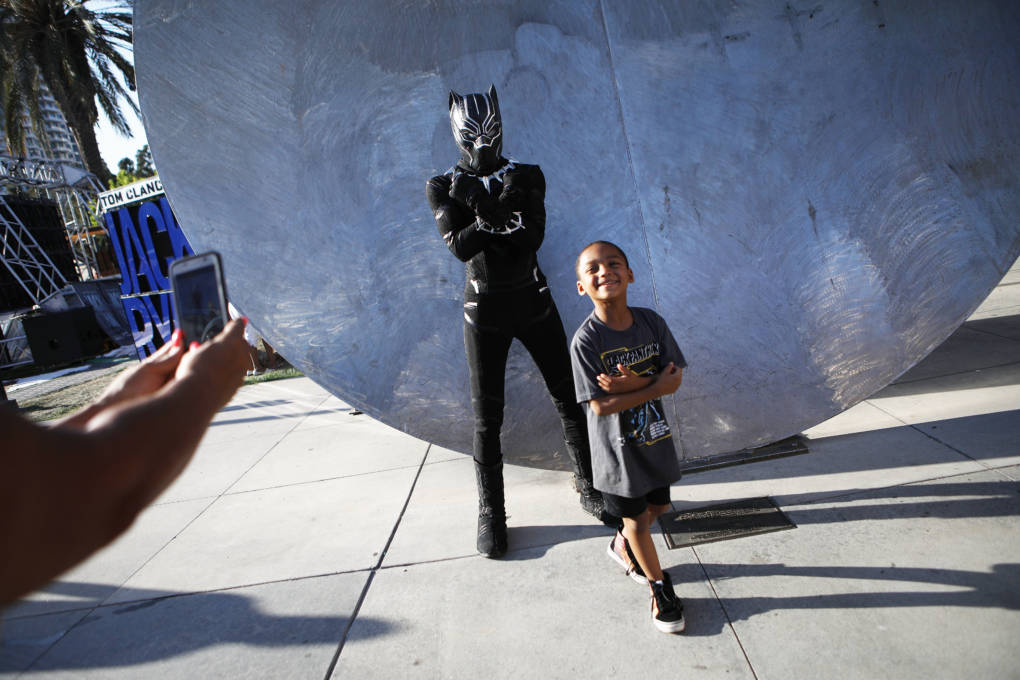 A boy smiles after posing with a cosplayer dressed as Black Panther outside San Diego Comic-Con on July 19, 2018 in San Diego, California.