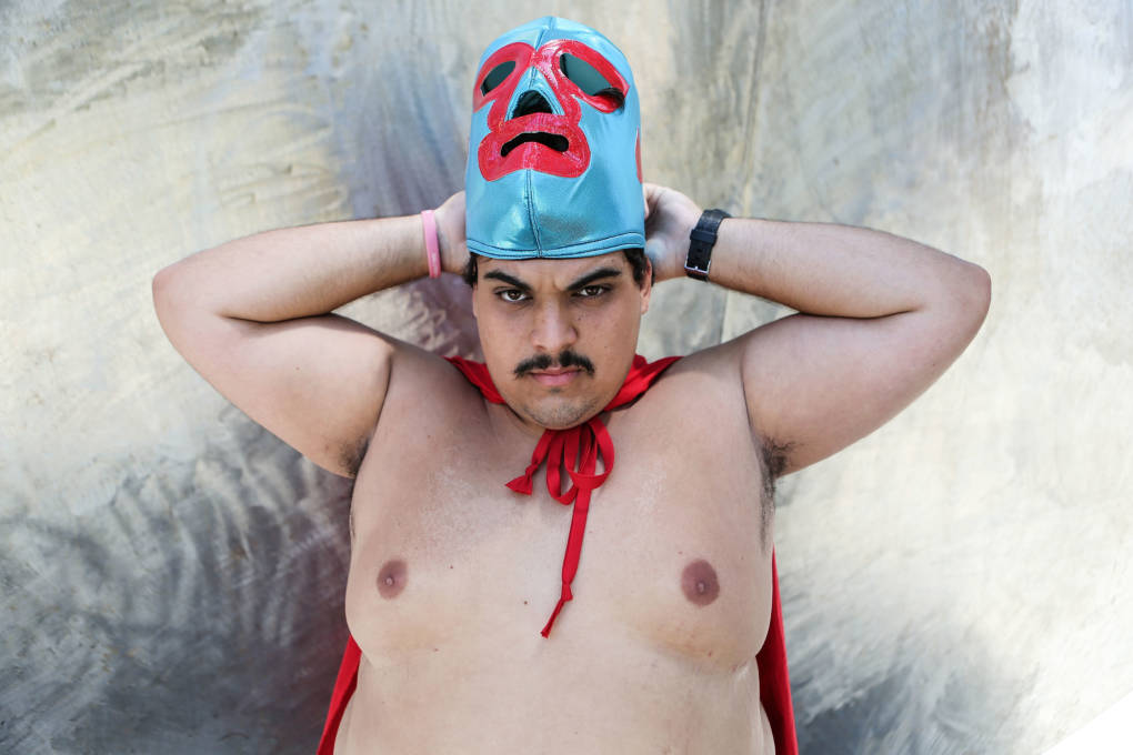 A cosplayer poses while adjusting his mask dressed as Nacho Libre outside San Diego Comic-Con.