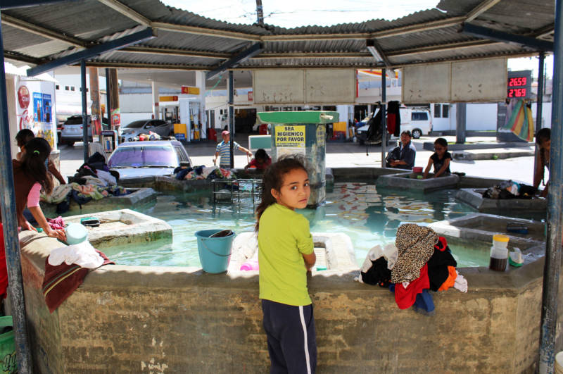 A 5-year-old girl helps her grandmother wash clothes at Huehuetenango’s municipal wash tub.