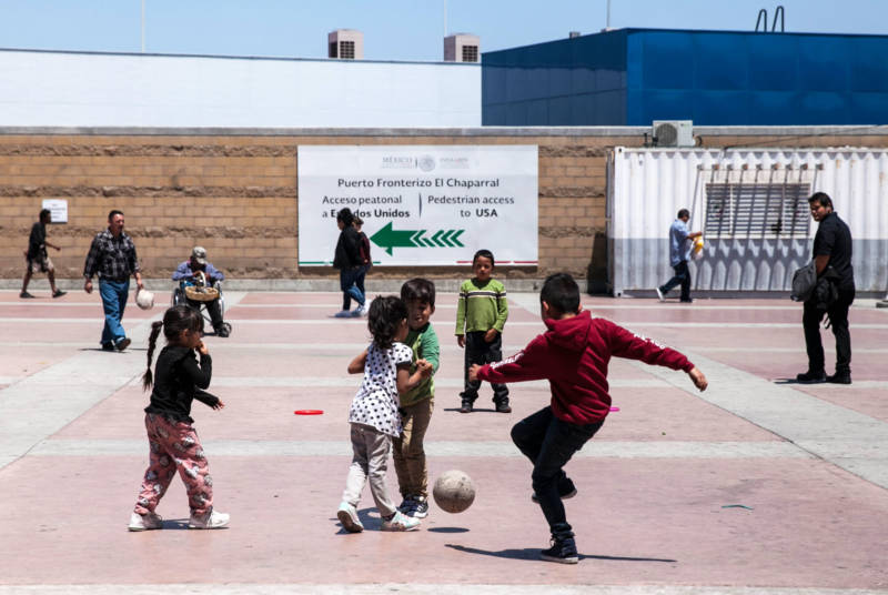 Children play soccer on the Mexican side of the San Ysidro port of entry. Many of the families waiting here spent their life savings to get here, in the hopes of legally entering the U.S. by applying for asylum.