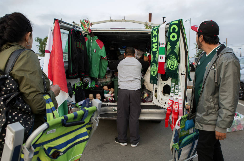 Martin Almanza, of San Jose, organizes jerseys, football scarves and memorabilia to sell to Mexico supporters during the game.