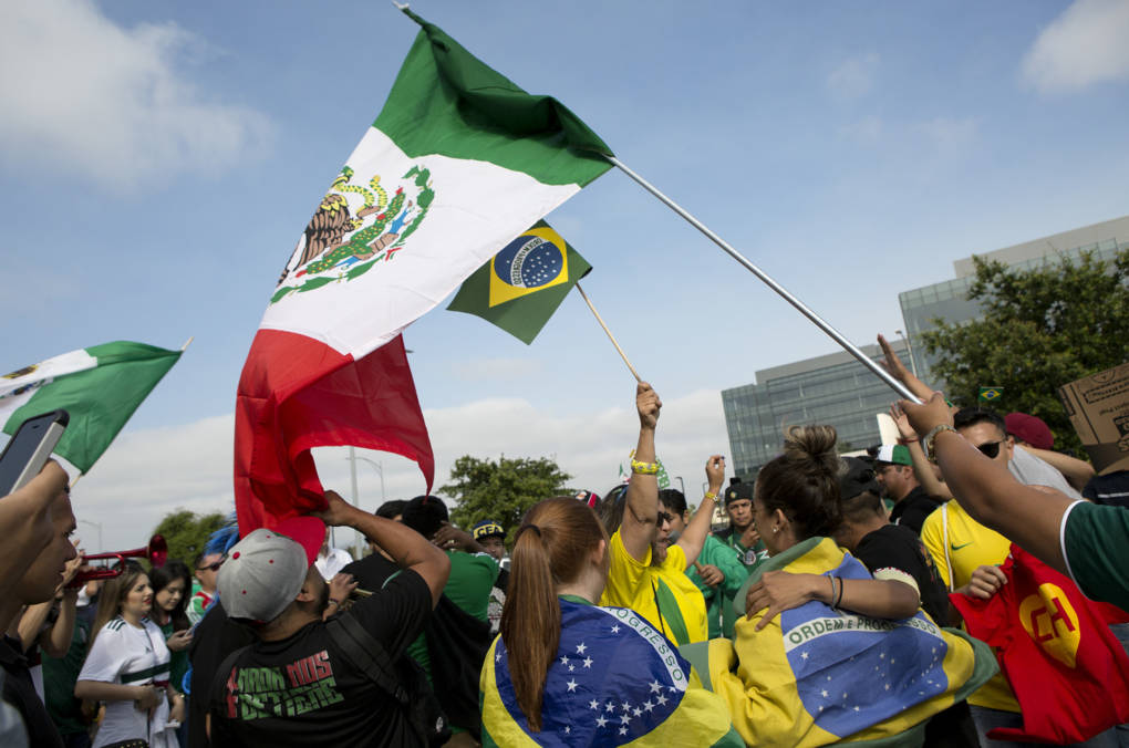 Mexico fans invite Brazil fans to join in their reveling following the game. Natalia Miller, lower left, said the two countries' fan culture are similar. "We party if we lose, party if we win."