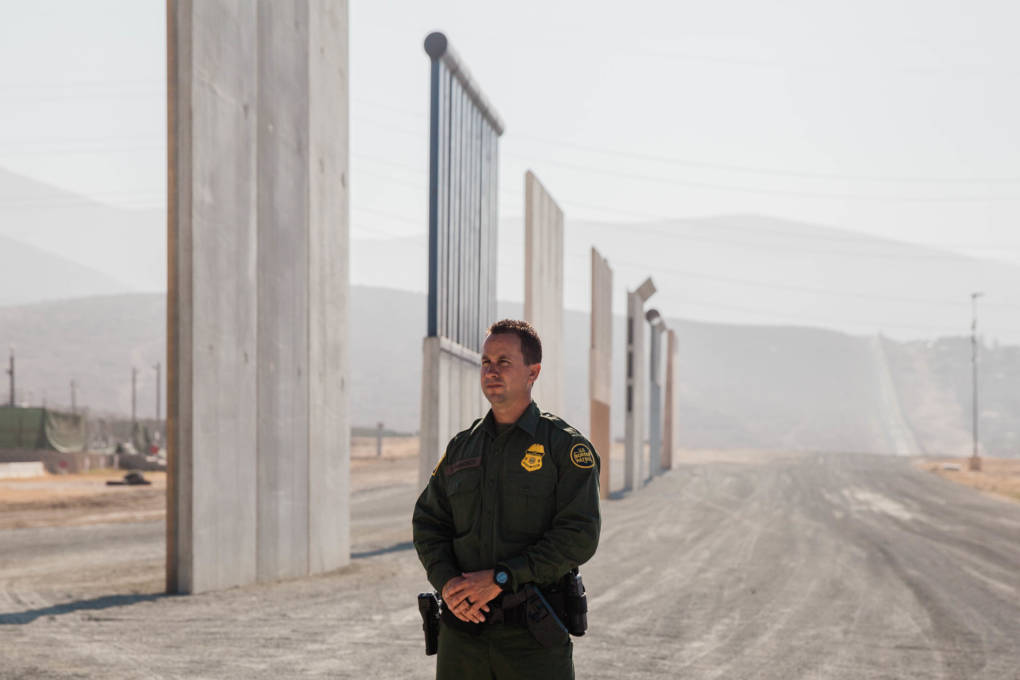 Theron Francisco, the Public Affairs Officer with the U.S. Border Patrol, stands in front of the border wall prototypes in Otay Mesa, Calif. Before joining the U.S. Border Patrol, Theron worked in construction. He said his grandmother came to the United States from Tijuana when she was very young.