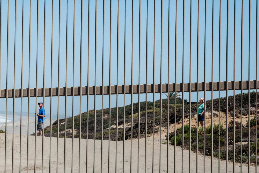 People outside the gate of Friendship Park looking at the border fence that goes into the Pacific Ocean in San Ysidro, Calif. Friendship Park is open on Saturdays and Sundays for four hours. Friends and family members are able to visit one another and speak through a metal fence.