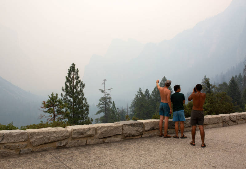 Trent Pederson, Miguel Vega and Yesun Park, residents of Mariposa, took in what they could see at Yosemite's famous Tunnel View viewpoint on Saturday, July 21, prior to the park's shutdown due to the Ferguson Fire. 