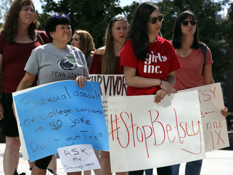 Sonja Breda, 23, right, holds a sign saying "Stop Betsy" as a group of survivors of sexual violence and their supporters gathered to protest proposed changes to Title IX before a speech by Education Secretary Betsy DeVos on Sept. 7, 2017, at the George Mason University Arlington, Va., campus.