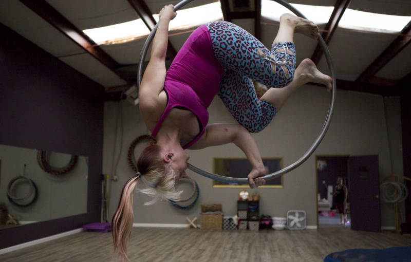 Sabrina in an upside-down "Lady in the Moon" pose on her aerial hoop. 