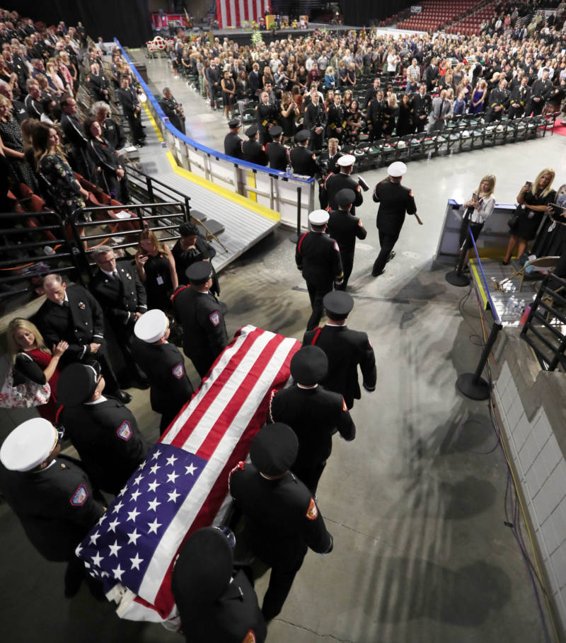 An honor guard brings the casket of Battalion Chief Matthew David Burchett into the Maverik Center for his funeral on August 20 in West Valley City, Utah.