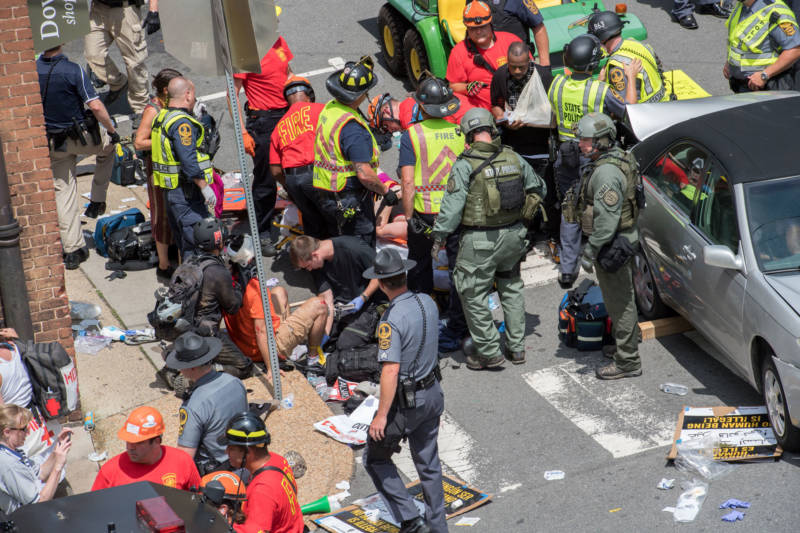 People receive first-aid at the scene where 21-year-old James Fields Jr. plowed his car into a crowd of peaceful protesters in Charlottesville on Aug. 12, 2017. Heather Heyer, 32, was killed.