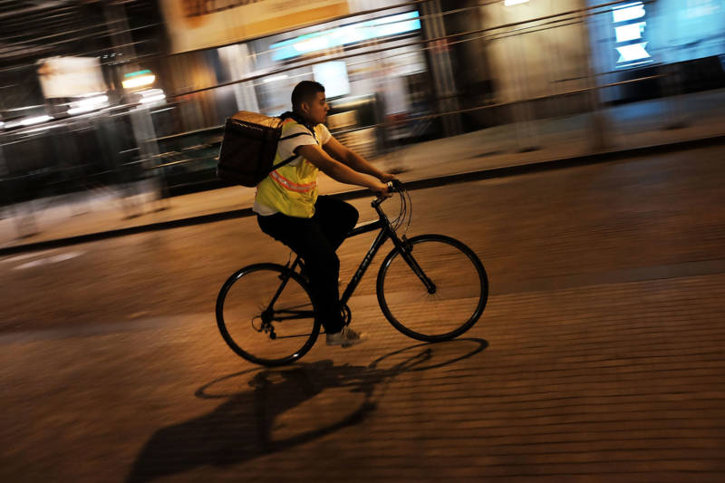 A third-party app food delivery worker transports food on his bicycle. Tacolicious co-owner Sara Deseran says third-party delivery apps have changed how she runs her restaurant.
