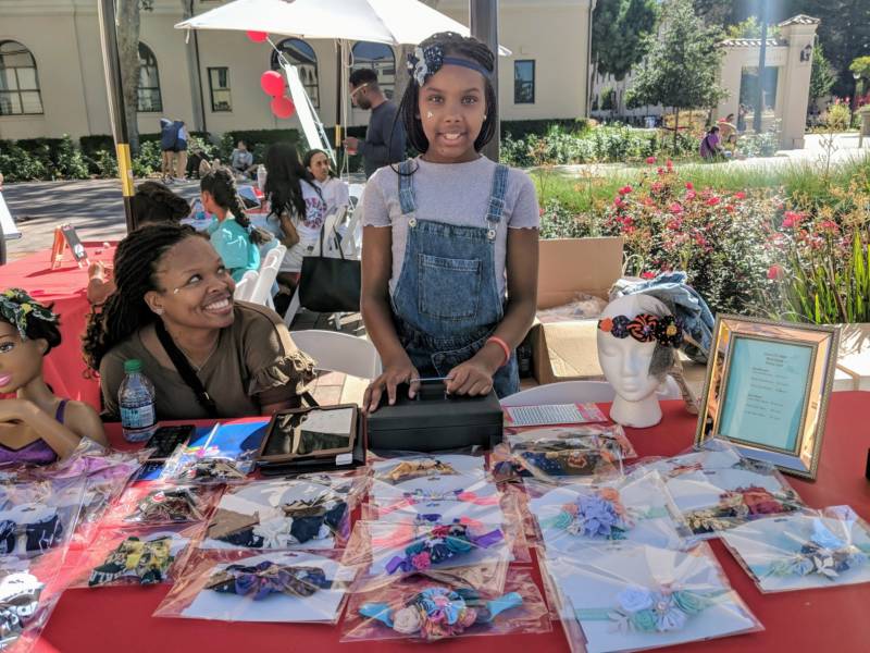 Jada Jackson from Oakland, 10, stands at her booth at the pop-up marketplace featuring young girl entrepreneurs. She was selling her handmade headbands and hairbows.