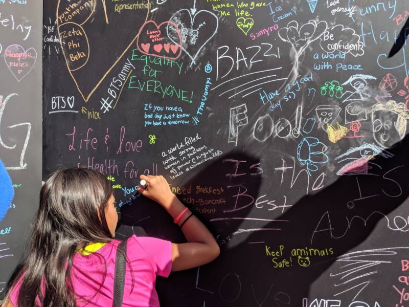 A young girl writes on a response board at the Girls' Festival. 'We call it a day of power and possibility. As women and girls we need to know there are so many opportunities for us to shine, and expand, and become leaders,' said Maureen Broderick, founder and CEO of WorldWideWomen, which organized the event.