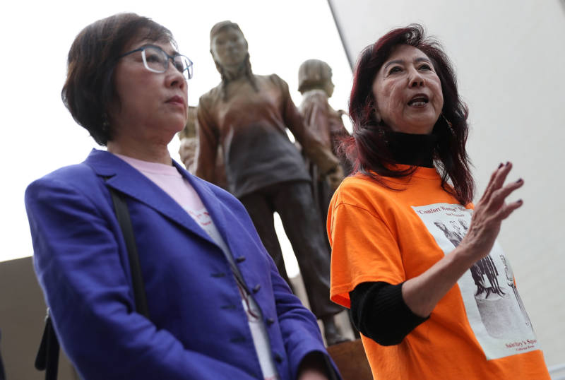 Retired judges Julie Tang (L) and Lillian Sing (R), co-charis of the Comfort Women Justice Coalition, speak during a news conference next to the 'Column of Strength' statue on Oct. 3, 2018.