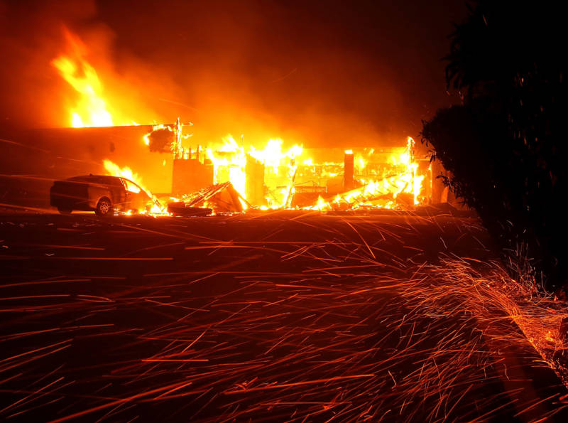 Embers blow in the wind as the Camp Fire burns a restaurant on Nov. 8, 2018 in Paradise.