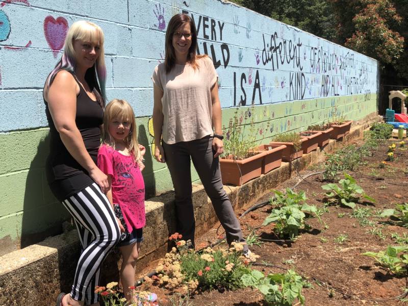 Sabrina Hanes (left), daughter Aroara, and Kelly Doty (right) in the garden at nonprofit Youth for Change in Paradise. This office and garden burned in the Camp Fire blaze.