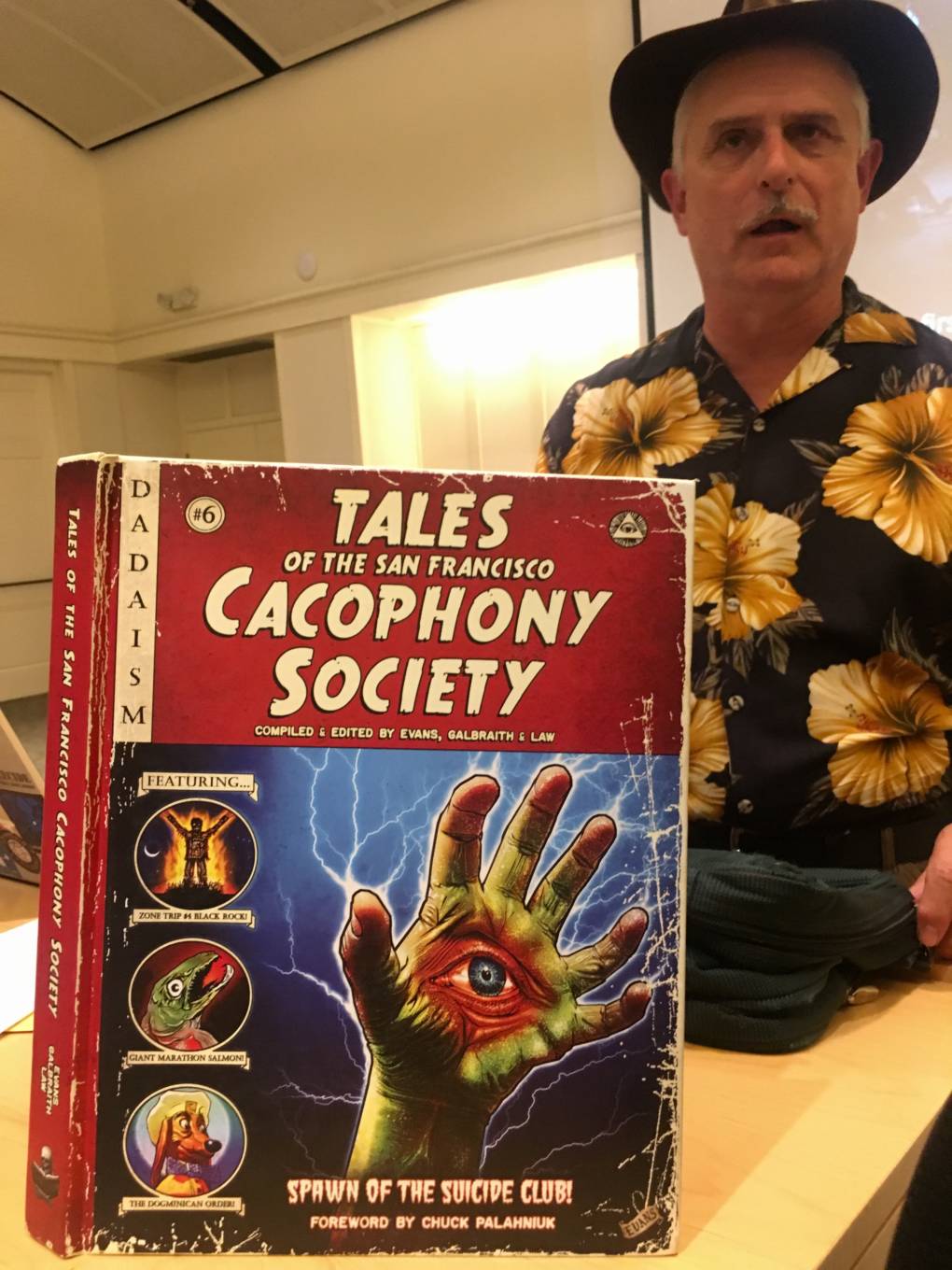 John Law stands behind a book about the Cacophony Society.