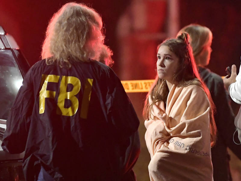An FBI agent talks to a potential witness to the shooting at the Borderline Bar and Grill in Thousand Oaks, where a gunman opened fire inside the country dance bar on "college night."