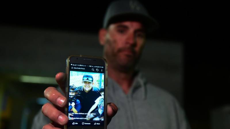 Jason Coffman displays a photo outside the Thousands Oaks Teen Center as he tried to locate his son Cody, who was at the Borderline Bar and Grill in Thousand Oaks, Calif.