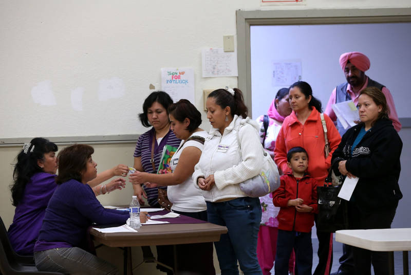 People wait to register for helath care insurance during an enrollment fair on March 28, 2014 in Bay Point.
