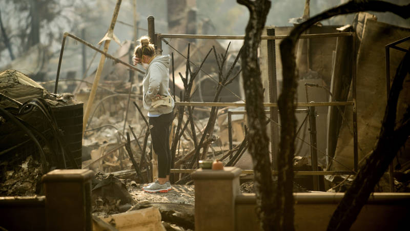 Bree Laubacher pauses while sifting through rubble at her Ventura, Calif., home following the Thomas Fire in December 2017.