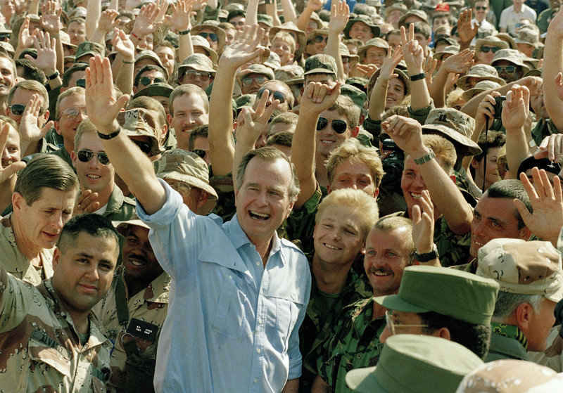 President Bush poses with soldiers during a stop at an air base in Dhahran, Saudi Arabia, on Nov. 22, 1990.