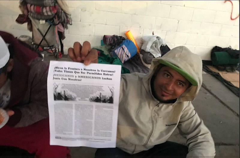 A migrant holds up a BAMN flyer on Nov. 26, 2018.