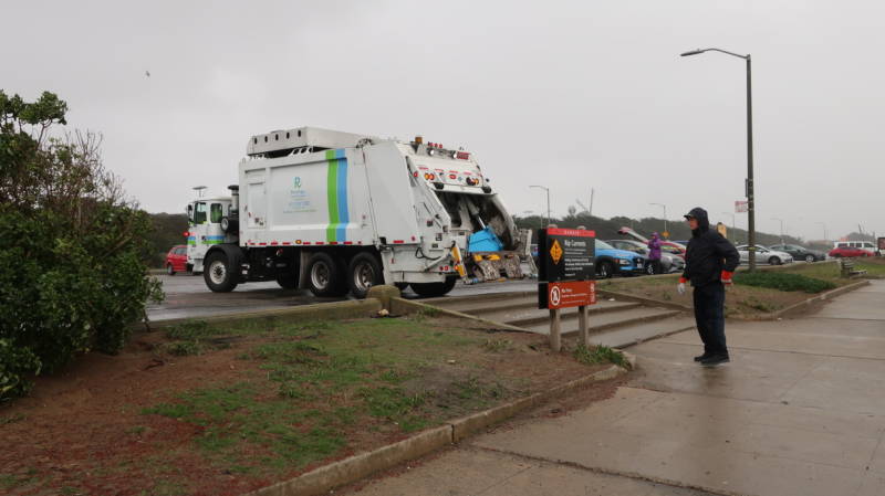 A Recology truck helps haul away trash collected at Ocean Beach.