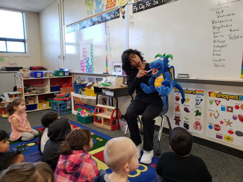 Dental hygienist Deborah Delfino shows a group of preschoolers in Lathrop, California how to brush their teeth by demonstrating with a puppet named Bob.