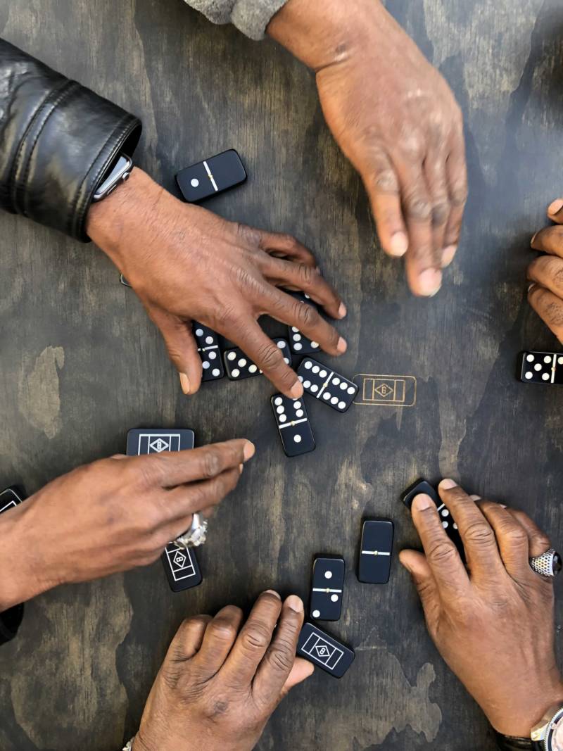 Al Wilken, Dre White, Brandon Nelson and Zac Malone play dominoes at the Black Joy Parade in Oakland on Sunday.