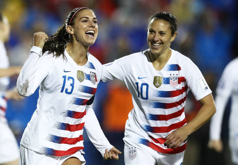 Alex Morgan #13 and Carli Lloyd #10 celebrate during the CONCACAF Women's Championship final match on Oct. 17, 2018. Morgan and Lloyd are both named as plaintiffs in the team's gender discrimination lawsuit.