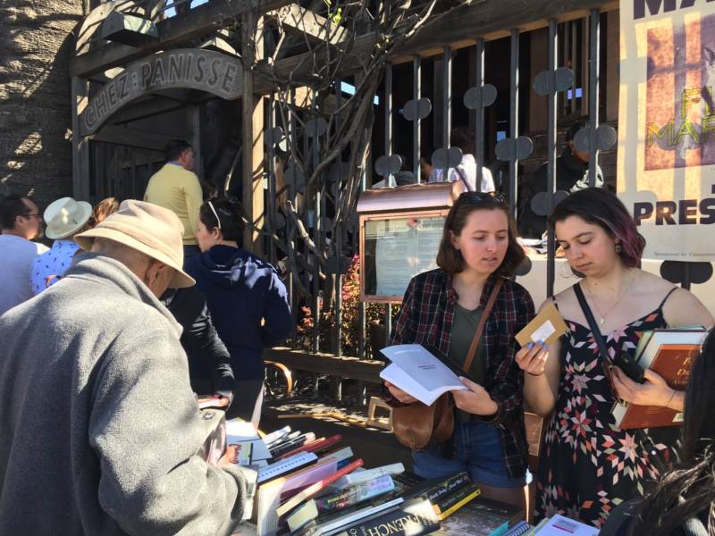 Two women browse for cookbooks and more outside Chez Panisse in North Berkeley. People came from all over the Bay Area to look through chef Alice Waters' belongings.