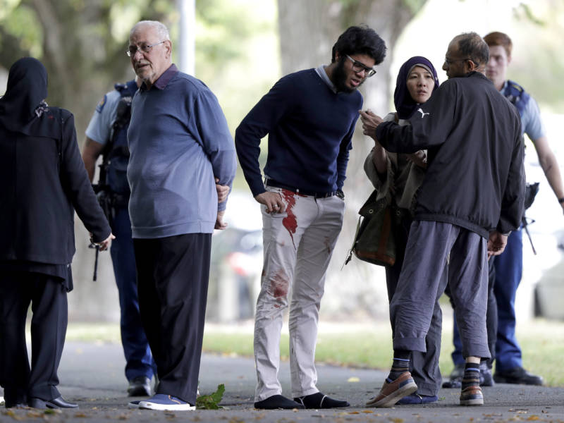 People stand across the road from a mosque in central Christchurch, New Zealand, following shootings at two mosques that killed 49 people on Friday.