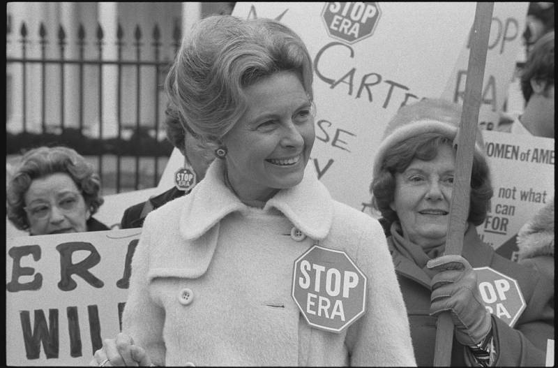 Activist Phyllis Schlafly wearing a "Stop ERA" badge, demonstrating with other women against the Equal Rights Amendment in front of the White House in February 1977.