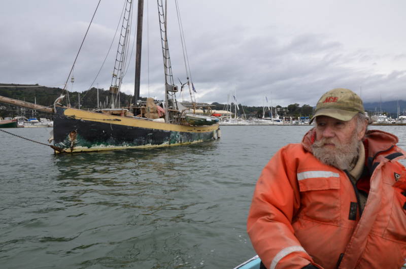 Greg Baker has had several boats since he first became an anchor-out on Richardson Bay in 1963. His current boat is anchored behind him.