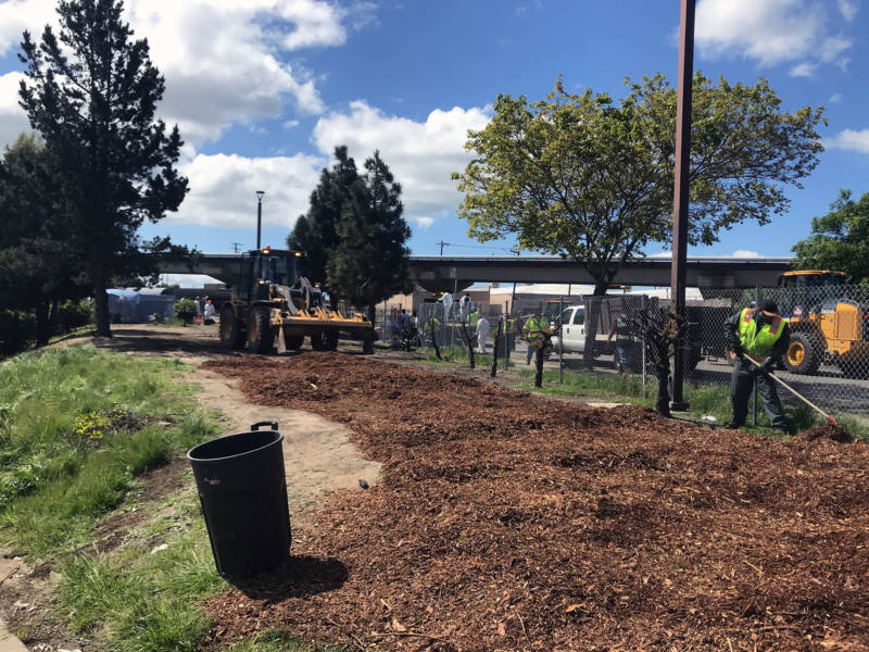 Mulch is spread over the site of the former Richmond homeless encampment on April 16, 2019.