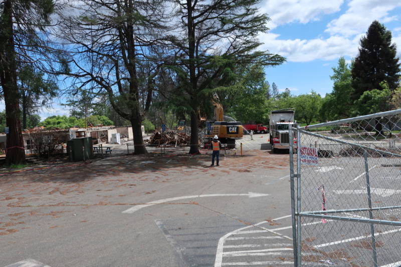 Workers with a backhoe remove debris from the burned down Paradise Elementary.
