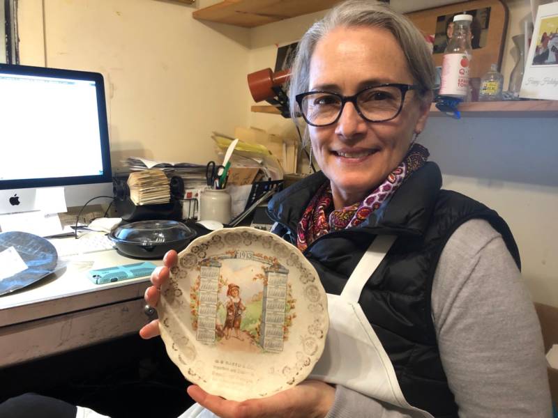 Elena Durante holds up an engraved plate from the early days of Ratto's International Market and Deli. Durante's great-grandfather opened the store in 1897.