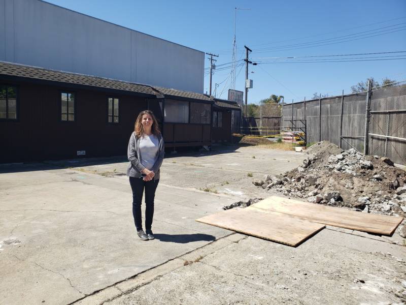 Mission Kids Co-Director Christina Maluenda Marchiel stands on the site of the school's future location.