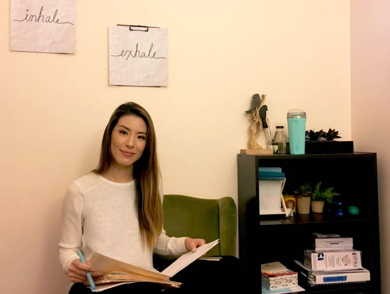 Sophia Ng reviews some paperwork in an office at Lowell High School's Wellness Center. As a mental health therapist, Ng visited schools in San Francisco and counseled students.