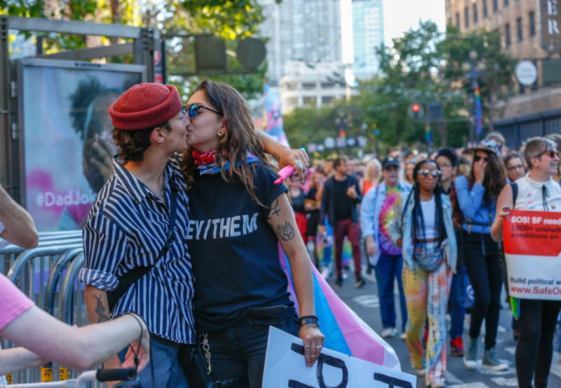 Two people embrace along Market Street during the Trans March.