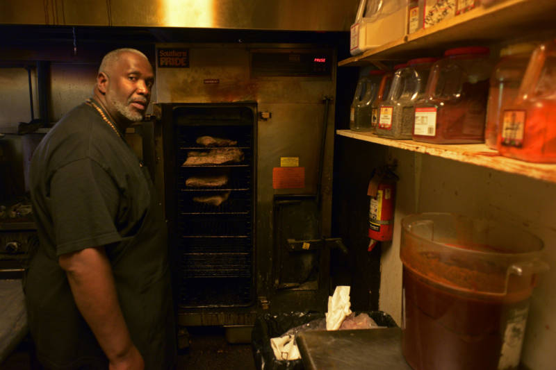 Joel McCarter, a graduate of the Quentin Cooks program at San Quentin State Prison, now works at Smoke Berkeley. He is seen standing in front of the restaurant's large smoker preparing the next day's brisket on May 28, 2019, in Berkeley.