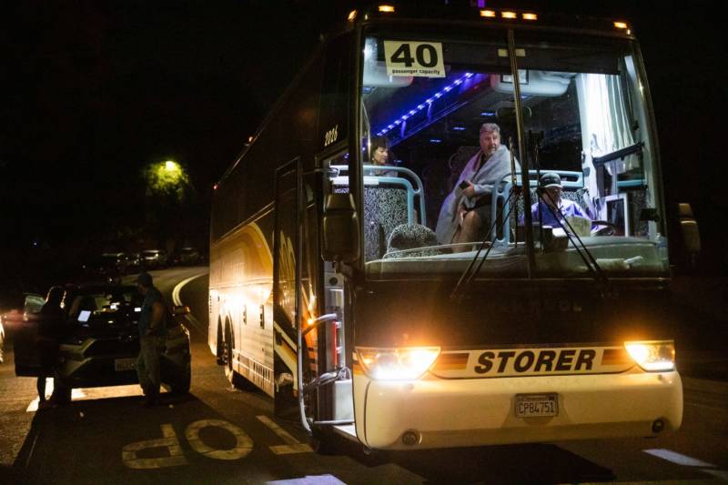 Evaucees Jane and Edward Jacobucci wait on a chartered bus after leaving the scene of the deadly Gilroy Garlic Festival shooting in Gilroy on July 28, 2019. 