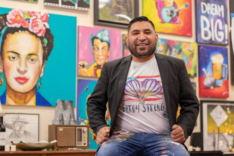 Ignacio "Nacho" Moya in his Gilroy studio on Aug. 5, 2019. Moya said his Mexican heritage, the community of Gilroy, where he grew up, and world events influence his artwork. He is wearing a T-shirt bearing artwork he created for a banner at a vigil the day after the July 28 shooting at the Garlic Festival.