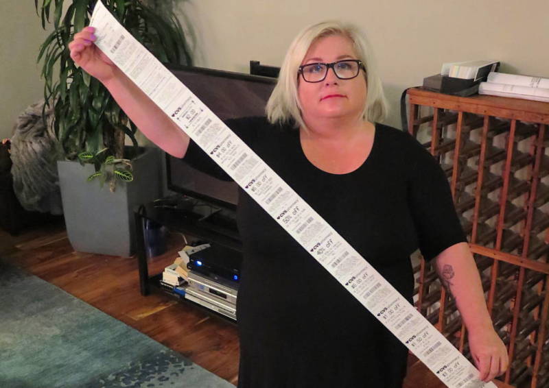 Carol Dahmen poses with a receipt that's more than 4 feet long — for the purchase of a single item. 