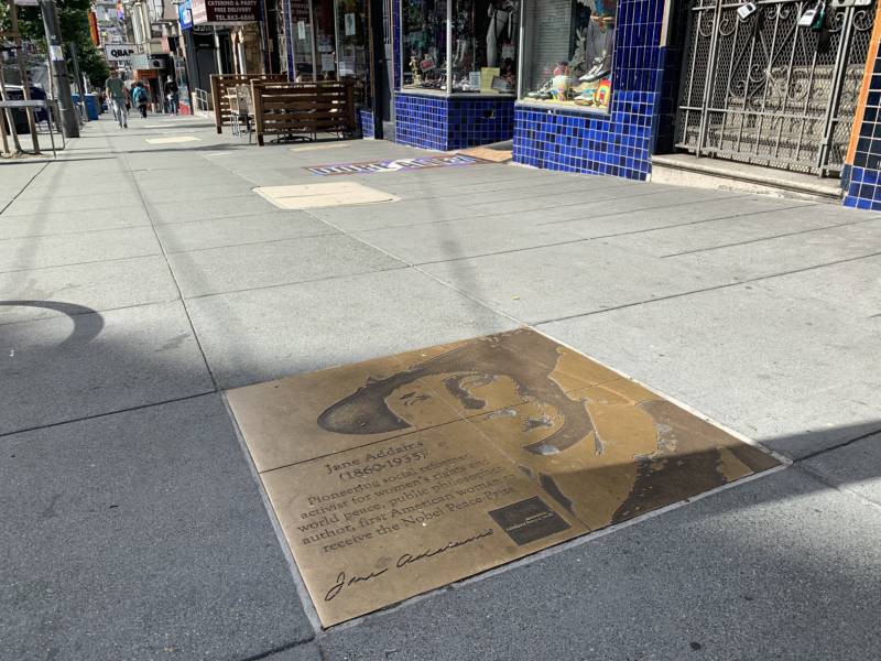 A sidewalk plaque on Castro Street in San Francisco honors Jane Addams, a pioneering social worker who won the Nobel Peace Prize in 1931.