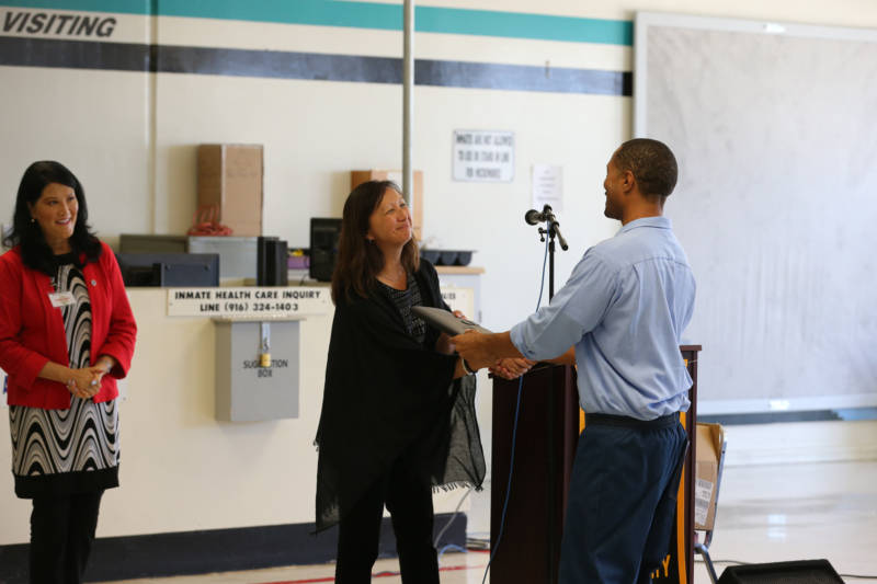 Tiffany Lam, who helped to create the B.A. program and now runs it, greets participating student inmates at Lancaster state prison in fall 2019. 