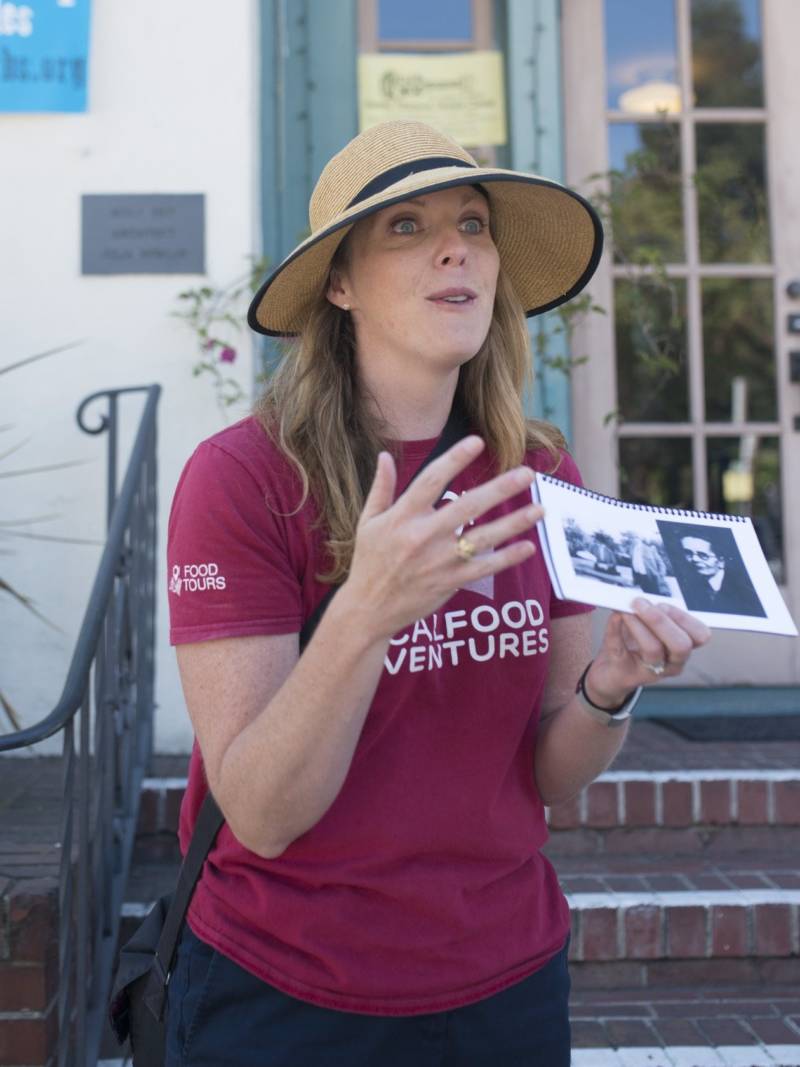 Tour guide Lauren Herpich, of Local Food Adventures, holds up historical photos as she gives an ice cream tour of Oakland's Rockridge neighborhood. 